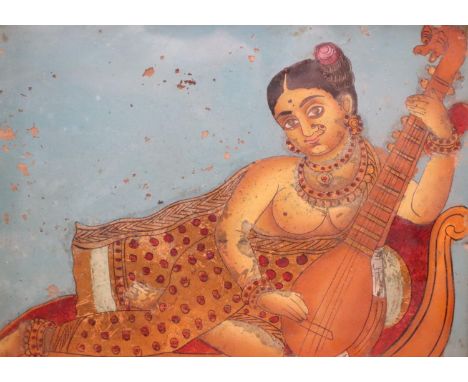 19th century Indian School, reverse painted and gilt glass, Woman playing a sitar, 25 x 30cm