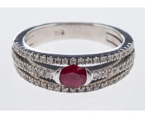 A diamond and ruby ring the central oval faceted stone with split band in 18ct white gold 



