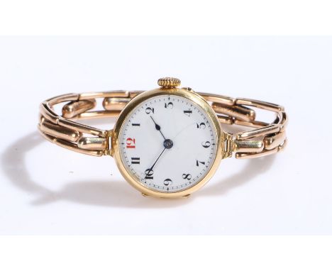 18 carat gold ladies wristwatch, the white dial with Arabic markers, manual wound, the case 25mm diameter, on a gilt bracelet