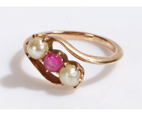 Gold coloured metal ring set with a red stone flanked by two pearls in a cross-over style setting, ring size K, 2.6g