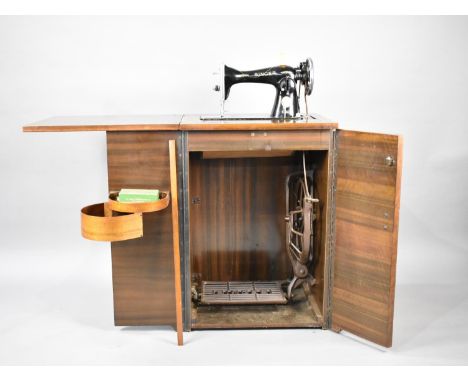 A Vintage Singer Treadle Sewing Machine in Workstation Cabinet having Folding Top and Twin Front Doors 