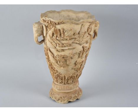 A Chinese Style Faux Ivory Vase decorated in Relief with Figures in Exterior Setting having Twin Elephant Mask Handles, 31cms