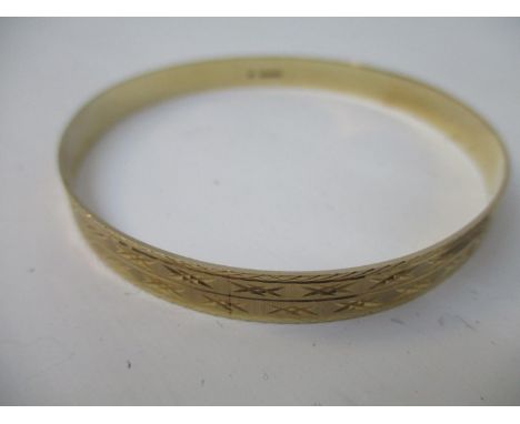 A 9ct yellow gold diamond cut pattern bangle, 2 3/4" dia, 10.70g 