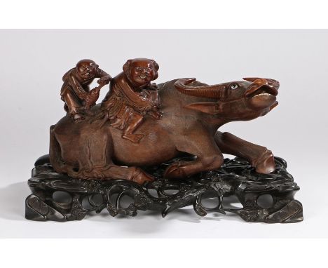 Chinese hardwood buffalo, the reclining buffalo with glass eyes and figures on the back, raised on a scroll tree branch carve