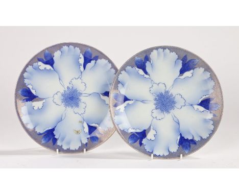 Pair of Japanese porcelain plates, with a central blue flower, one with two enamel butterflies, character mark to the base of