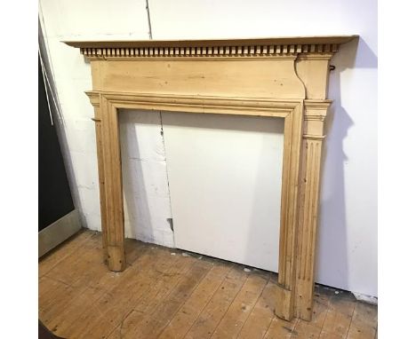 A Georgian inspired pine fire surround with dentil cornice and fluted pilasters (131cm x 144cm x 16cm)