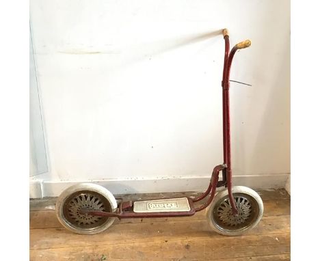 A vintage Tri-ang scooter, painted red, with Tri-ang Toys Ltd stamp to front