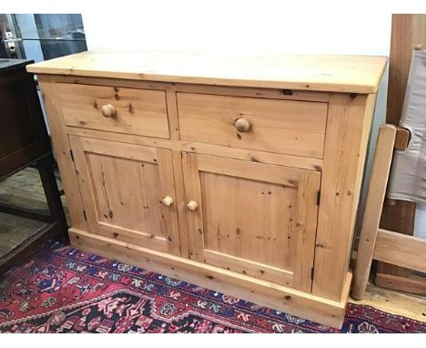 A modern pine side cabinet fitted two short drawers above a pair of cabinet doors, with single shelf to interior, on plinth b