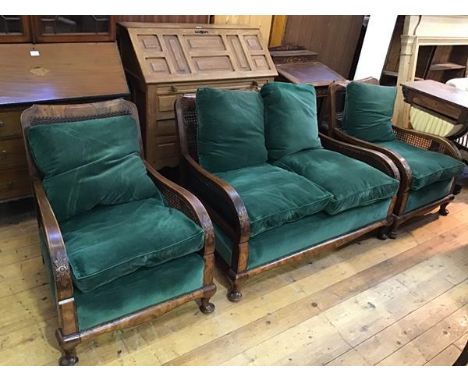 A 1920s bergere suite comprising a two seater sofa and two chairs with cane back and sides, with green upholstery, with front