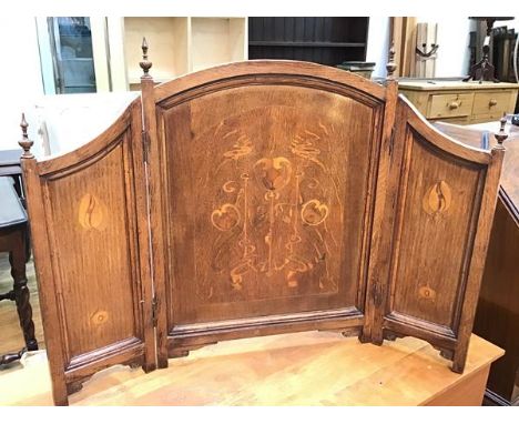 An Art Nouveau oak triptych, each panel with a stylised flower inlay (open: 64cm x 87cm)