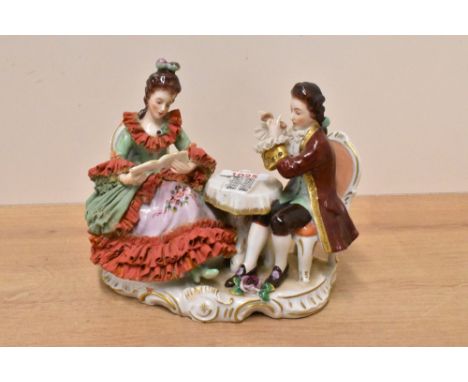 A 20th century Dresden porcelain figure group, 18th century figures seated, on a rocaile base, printed marks to underside, 17
