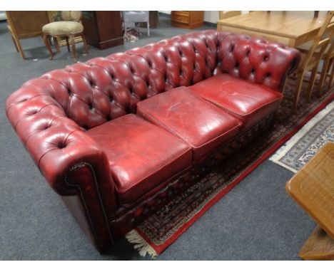 A three seater red button leather Chesterfield settee    