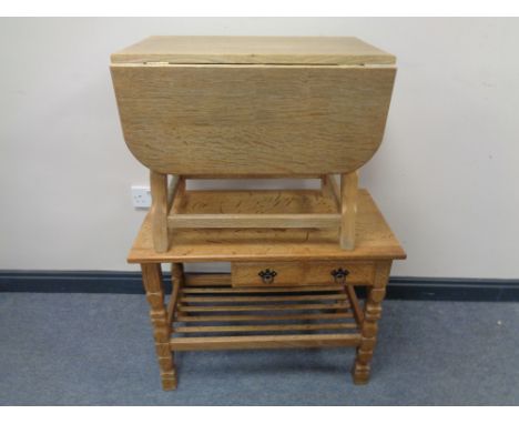 A blond oak flap sided coffee table together with a further blonde oak telephone table, fitted shelf beneath and two drawers 