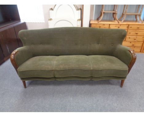 A mid 20th century wood armed three seater settee upholstered in a green button back fabric  