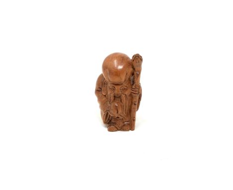 A carved hardwood Chinese netsuke - Man holding a staff