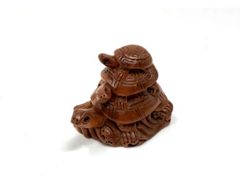 A carved hardwood Chinese netsuke - Three turtles standing on rocks