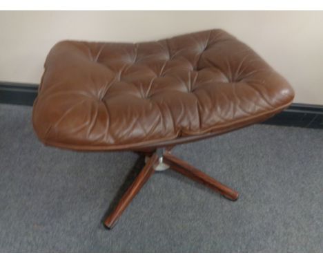 A 20th century brown button leather footstool on four way pedestal  