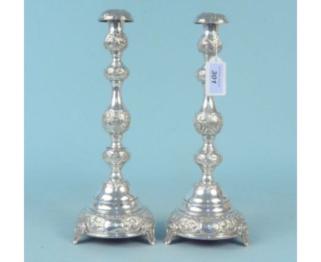 A pair of silver candlesticks with embossed floral and scroll design, hallmarked London 1920, makers mark rubbed, possibly J.
