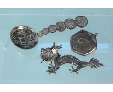 A Chinese silver spoon, a white metal medal of a dragon (as found) plus an English silver compact pendant (as found)