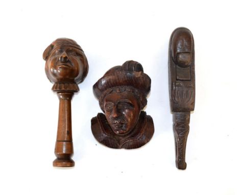 A German Treen Nutcracker, late 19th century, in the form of a caricature peasant's head on a column, 16.5cm long; Another Nu