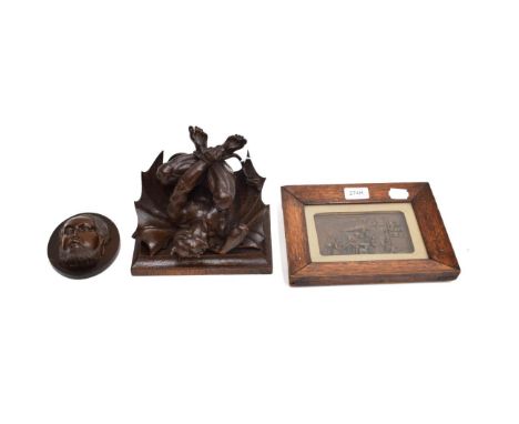 A 19th Century Oak Figural Wall Bracket, of rectangular form supported by a crouching imp, 16cm high; An Oval Plaque, carved 