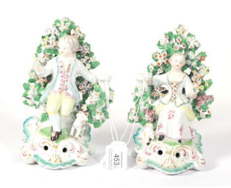 A Pair of Derby Porcelain Candlestick Figures, circa 1770, as a shepherd and shepherdess seated before bocage, he with a dog 