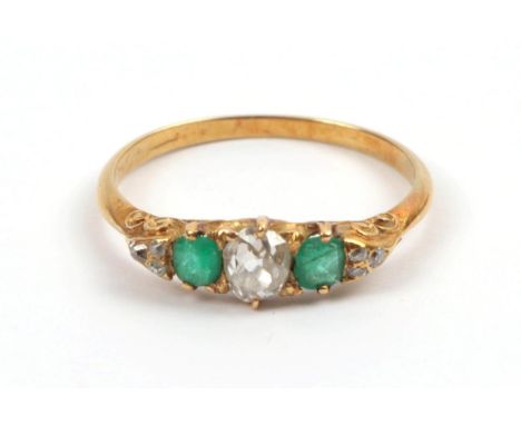 A Late 19th Century Emerald and Diamond Ring, an old cut diamond sits between two cushion cut emeralds, a trio of old cut dia