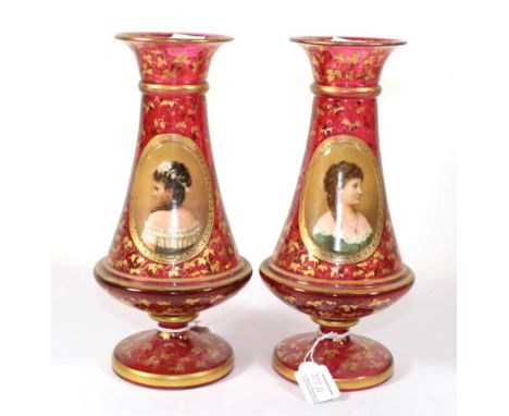 A Pair of Bohemian Ruby Glass Vases, circa 1900, decorated with bust portraits of young ladies in raised oval panels on a gil