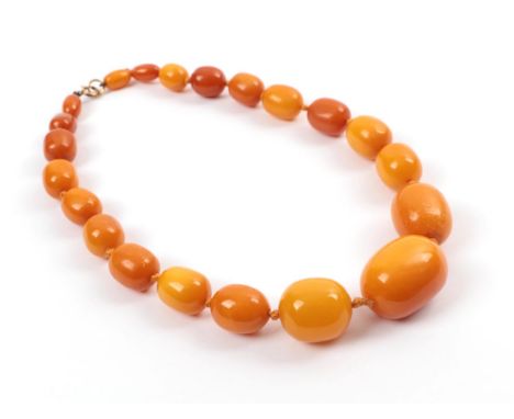 An Amber Bead Necklet, of 21 graduated barrel shaped beads, with variations in colour from yellow to light brown, length 44cm