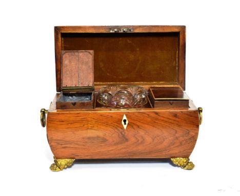 A Regency Gilt Metal Mounted Rosewood Tea Caddy and Hinged Cover, of sarcophagus form with ring handles and paw feet enclosin