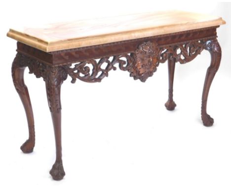 A continental mahogany console table, with a marble effect top, the base carved with a central mask flanked by scrolls, styli