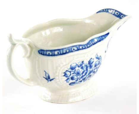 An 18thC porcelain sauce boat, of shaped slipper form with moulded body, ear handle, florally decorated in blue and white on 