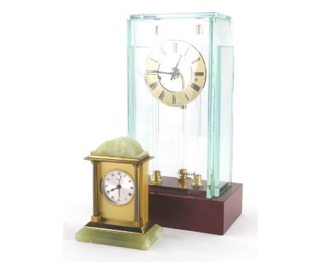 A Rapport mantel clock, with suspended 8cm diameter, Roman Numeric dial, in glazed case on wooden plinth base, 25cm high and 