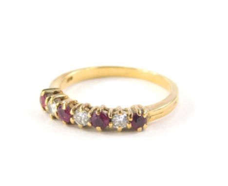 An 18ct gold diamond and ruby half hoop dress ring, set with three round brilliant cut diamonds, totalling approx 0.21cts, an