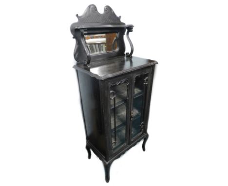 A late 19th/early 20thC ebonised side cabinet, the raised back with a shelf above a bevelled mirror plate, on scroll supports