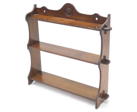 An early 20thC walnut three tier wall shelf, with shaped end supports, 61cm high, 66cm wide.