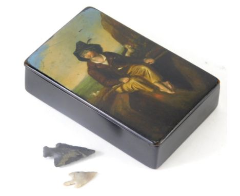 A 19thC papier mache snuff box, decorated with a figure on a shoreline, 9cm wide and two axe heads, one found by repute at th