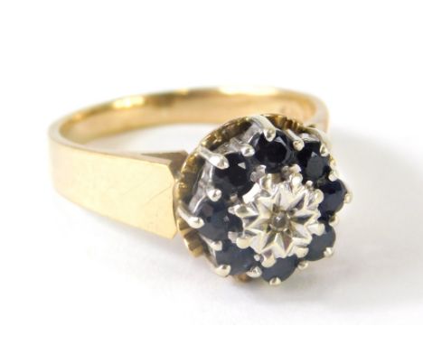 A ladies 9ct gold dress ring, florally claw set with small sapphires centred by a white stone, size N, 4.4g all in.