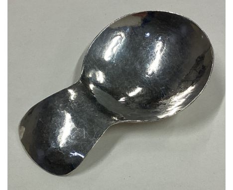 A silver caddy spoon with hammered decoration. Marked to reverse. By Camden School of Arts. Approx. 24 grams. Est. £30 - £40.