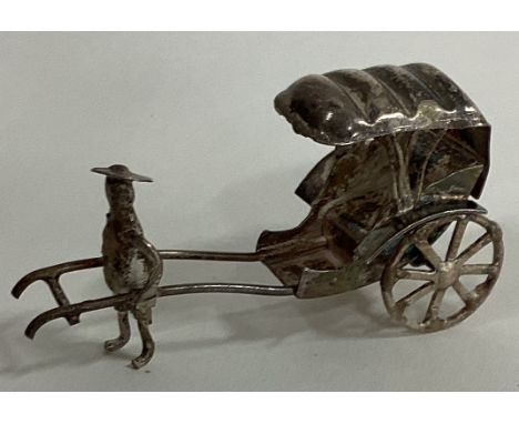 A Chinese silver table toy of a figure pulling a rickshaw. Approx. 10 grams. Est. £10 - £20.