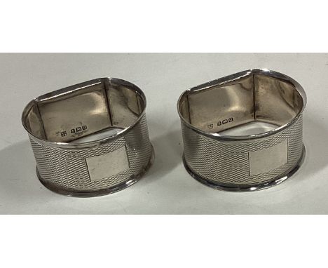 A pair of heavy silver napkin rings with engine turned decoration. Birmingham. Approx. 55 grams. Est. £30 - £40.