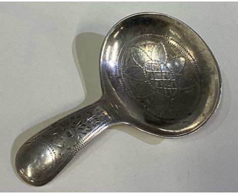 A bright-cut silver caddy spoon in the Georgian style. Marked to reverse. Approx. 11 grams. Est. £20 - £30.
