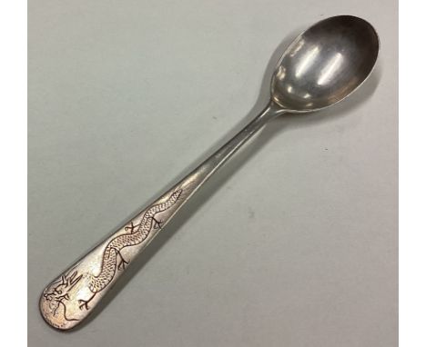 A large Chinese silver condiment spoon engraved with dragon decoration. Marked to reverse. Approx. 19 grams. Est. £30 - £40.