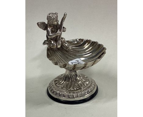 A silver salt in the form of a shell cast with cherub playing an instrument. Approx. 31 grams. Est. £30 - £40.