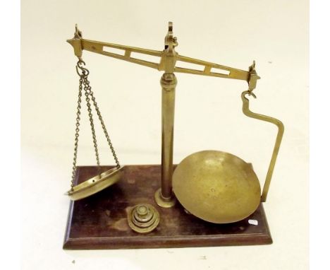 A set of brass balance scales on mahogany base 