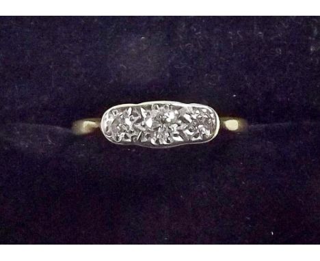 A gold three stone illusion set diamond ring 
