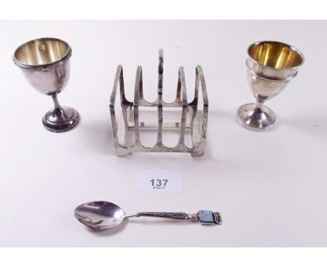 A small silver toast rack and a silver eggcup 4.4 ozs plus a French white metal eggcup and spoon