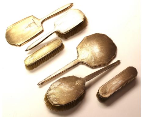 Two, three piece Art Deco silver dressing sets including hand mirror, hand brush and clothes brush, each with engine turned g