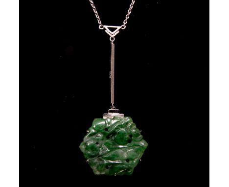 An Art Deco carved jade and white gold pendant, the reticulated hexagonal plaque suspended on a bar link, supported by a fine