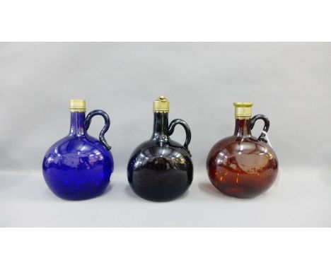 Three colored glass gin flasks with brass mounts to include two include an Amethyst colour, blue and amber, one with a stoppe
